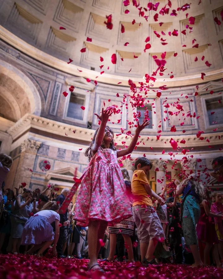 Girl catching falling rose petals during Pentecost at the Pantheon by Andreas Düren