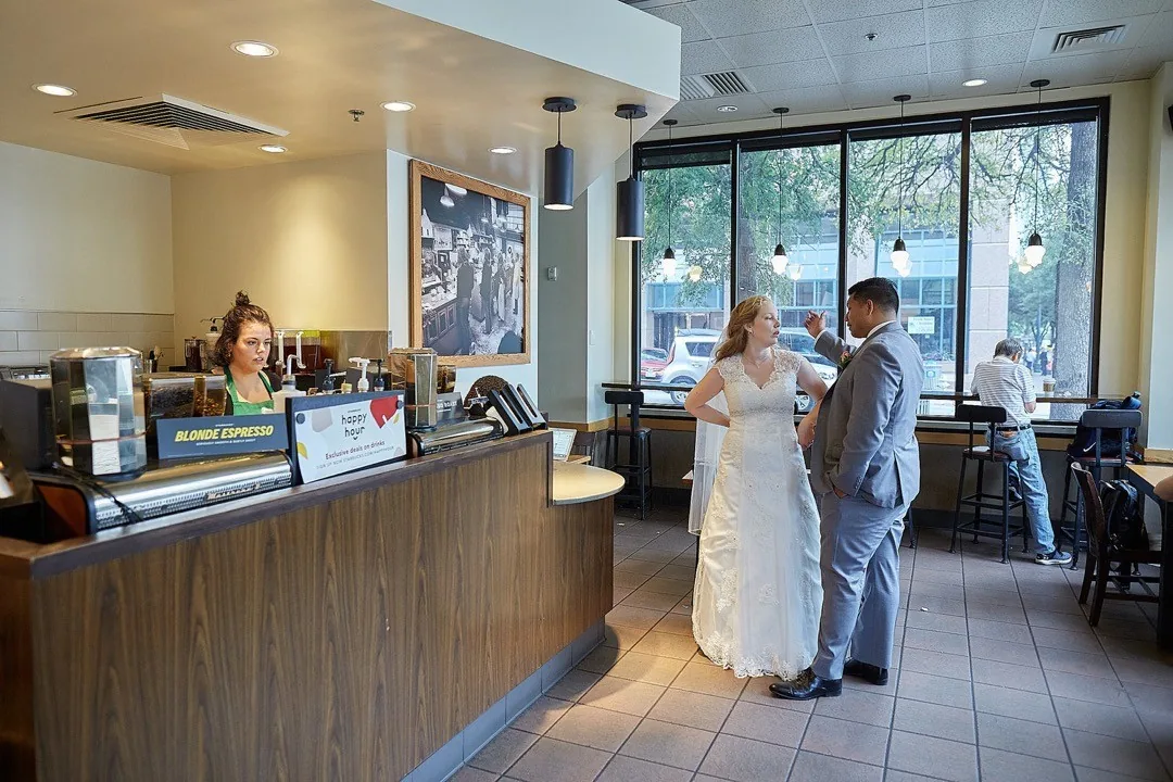 Bride and groom standing inside a café by Andreas Düren