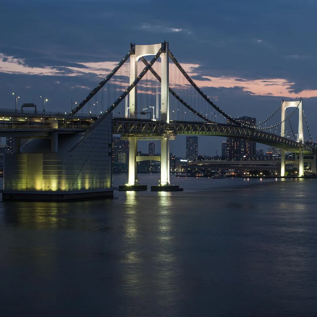 Illuminated suspension bridge over Tokyo Bay at dusk by Andreas Düren